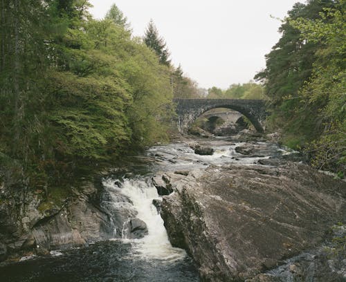 A river with a bridge over it and rocks