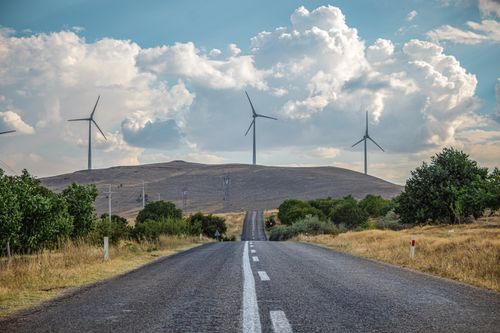 Free Scenic view of wind turbines along a rural road in Kayseri, Türkiye, capturing the essence of renewable energy. Stock Photo