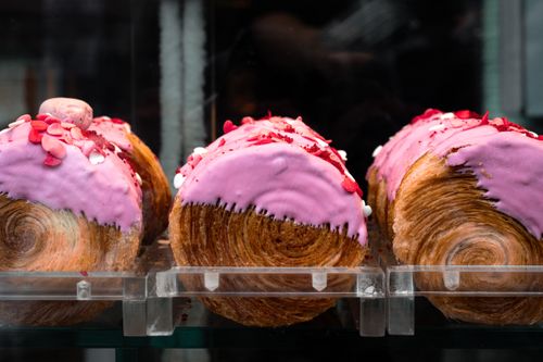 Free Tempting pink-frosted croissants with heart sprinkles on display in a São Paulo bakery. Stock Photo