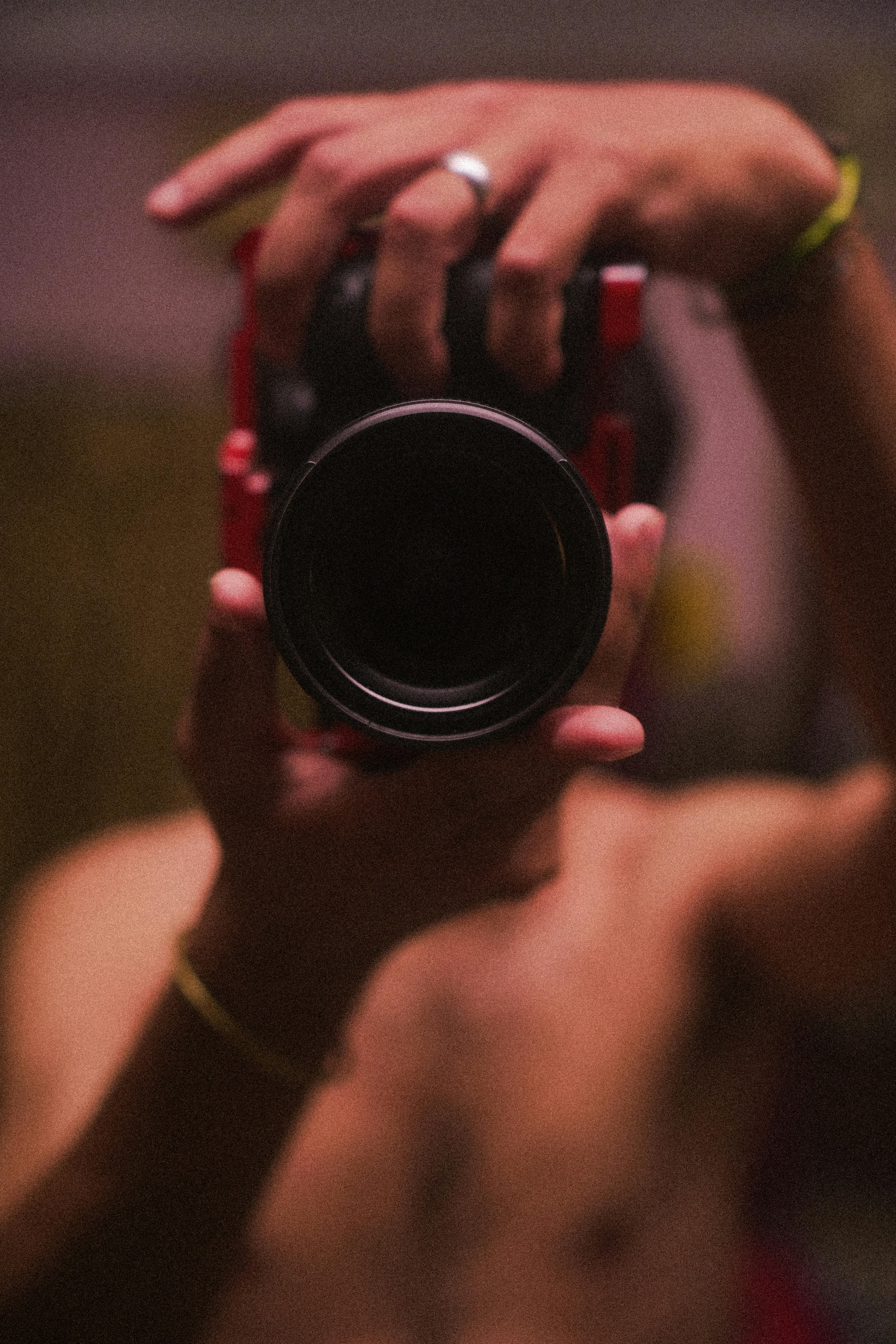 Free A close-up view of a person holding a camera, focusing on the lens and hands. Stock Photo