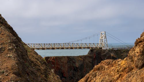 A bridge over a cliff with a view of the ocean