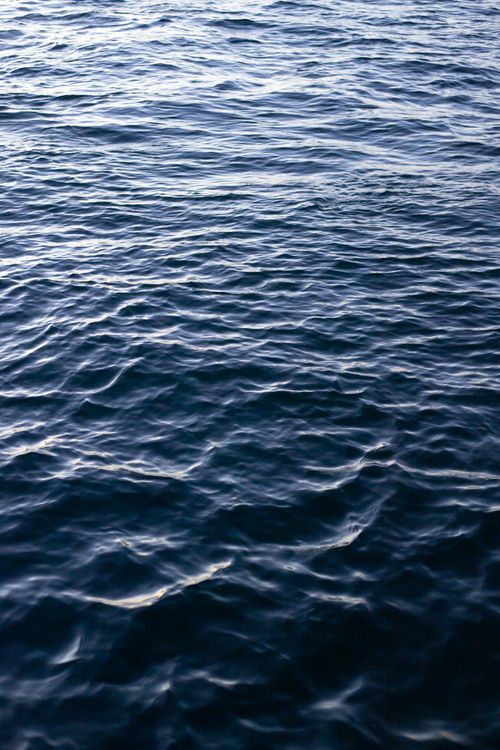 Free A tranquil view of ocean waves with soft sunlight reflecting on the surface, capturing the essence of calm nature. Stock Photo