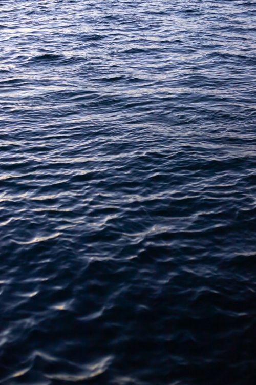 Free A serene vertical shot of a wavy ocean surface viewed from above, showcasing natural beauty. Stock Photo