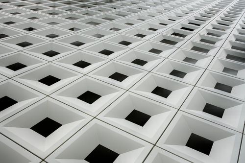 Free Abstract view of a futuristic architectural surface with repeating geometric square patterns. Stock Photo