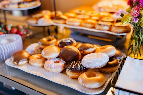 A buffet table with a variety of donuts and other food