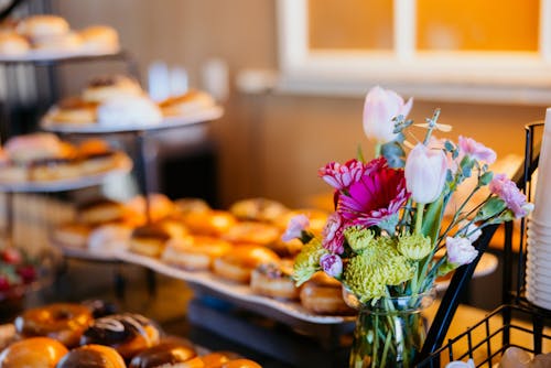 A buffet table with donuts and flowers on it