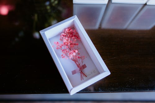 A small box with pink flowers in it on a table