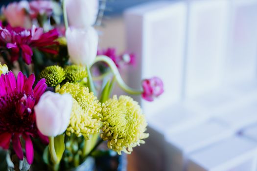 A vivid bouquet featuring pink gerberas, white tulips, and yellow chrysanthemums.