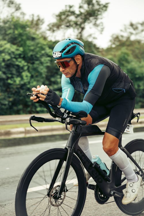 A man in a blue and black outfit riding a bike