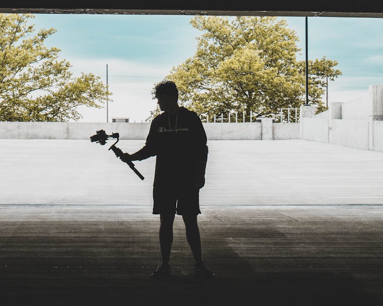 Silhouette Of A Man Carrying A Camera