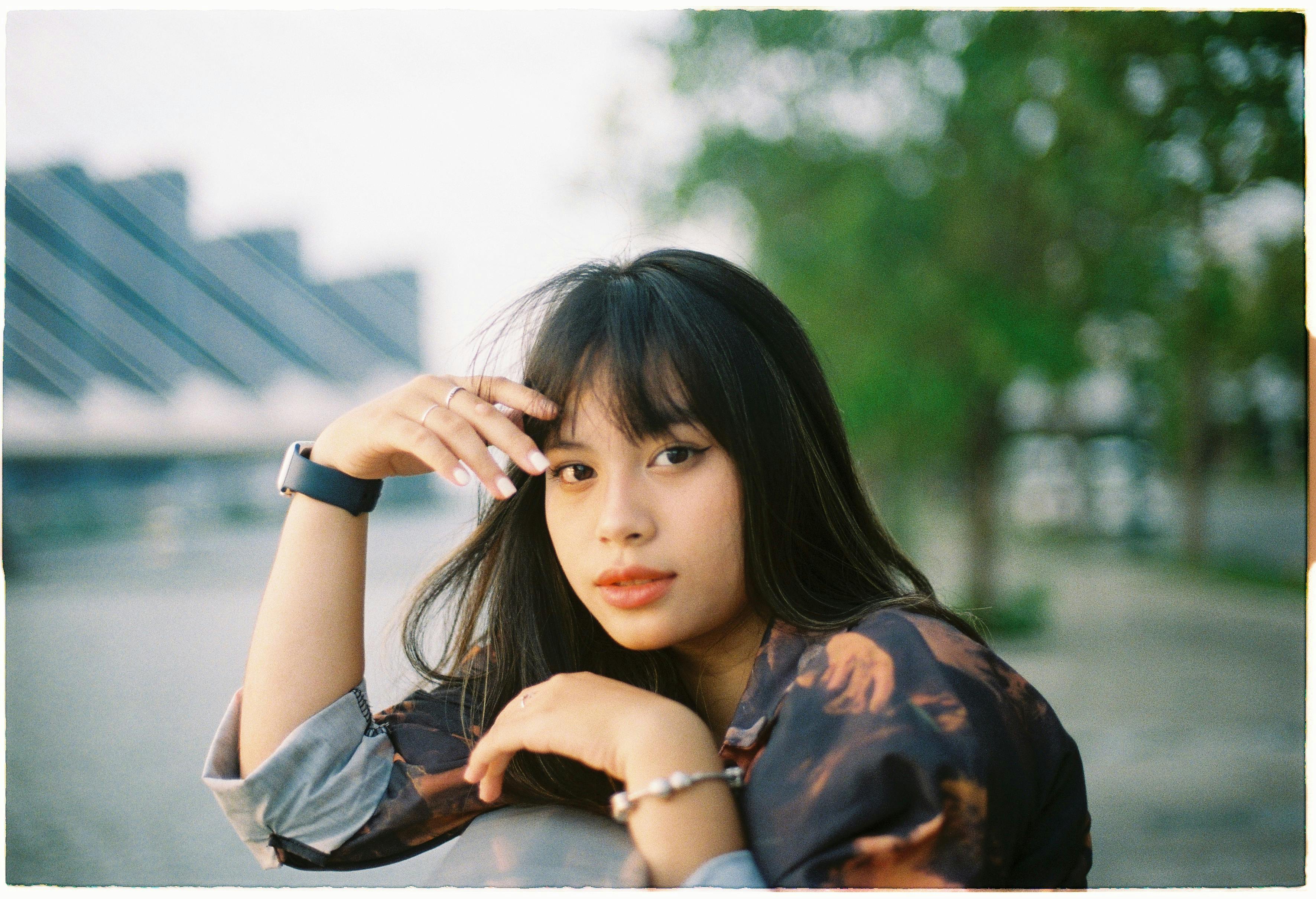 Portrait of a stylish young woman outdoors wearing a patterned jacket.