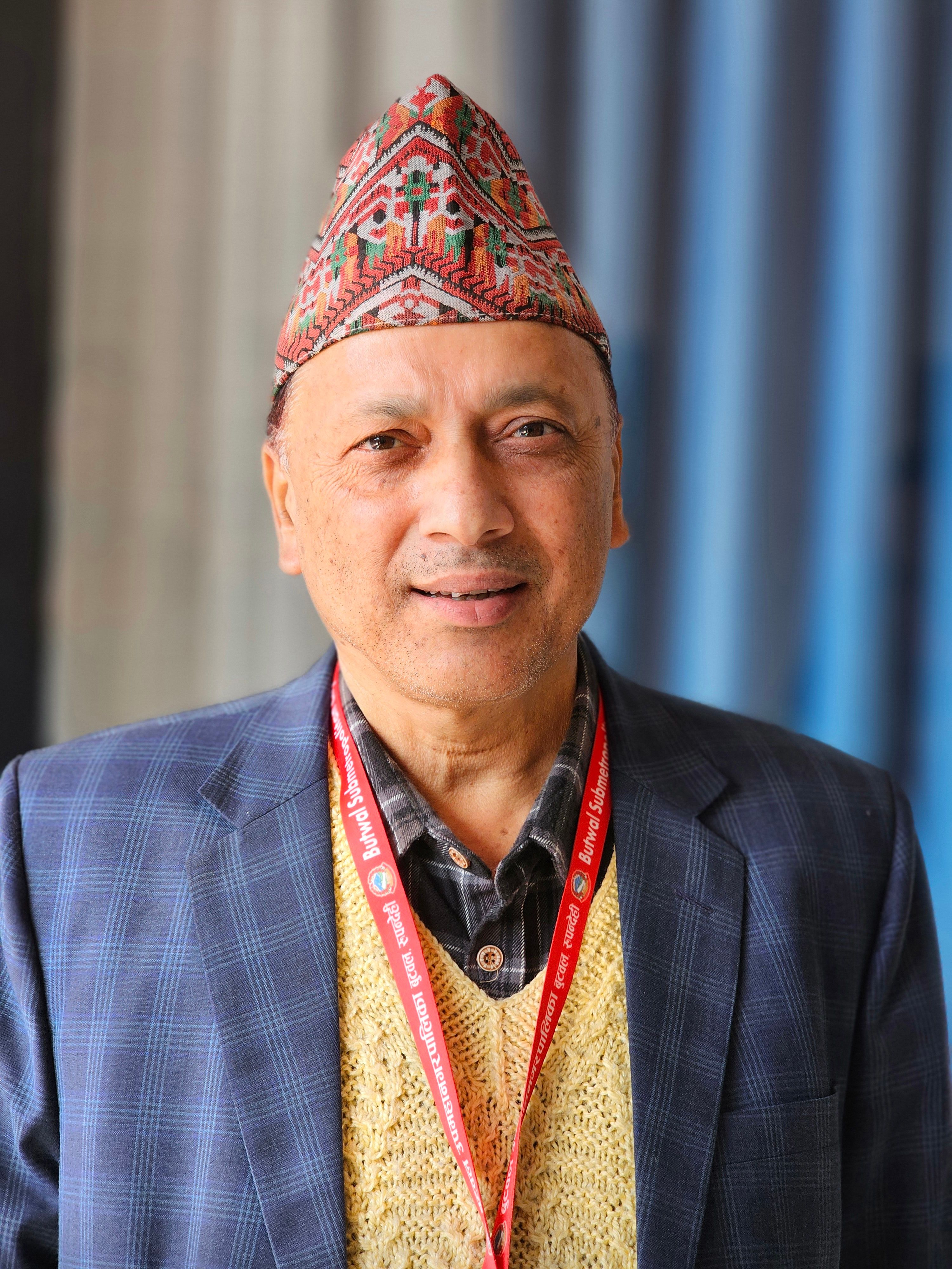 Portrait of an elderly man wearing a traditional hat and suit indoors.