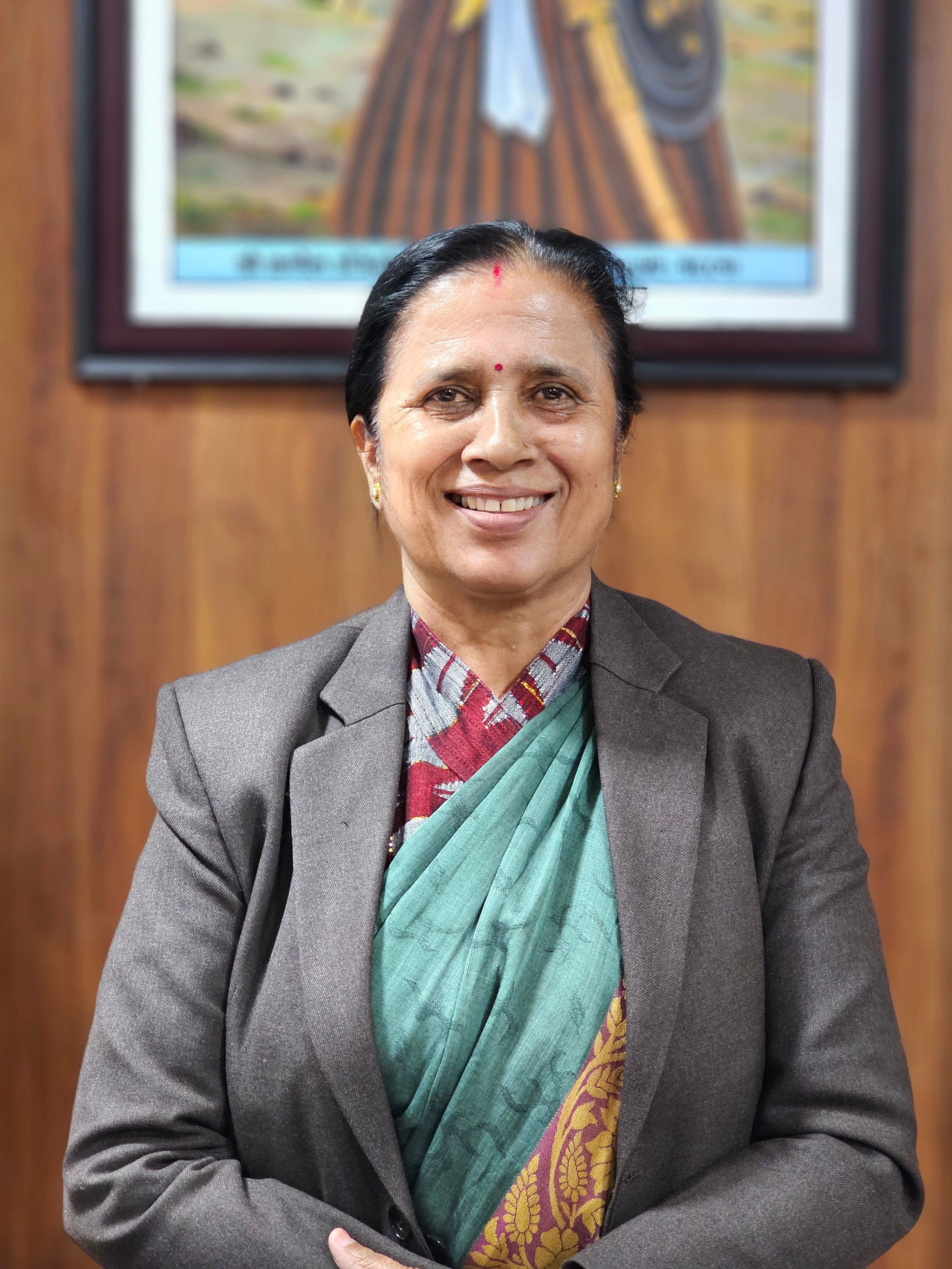 Portrait of a smiling woman wearing traditional and modern clothing indoors.