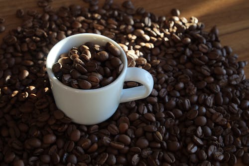 Coffee beans and a cup of coffee on a wooden table