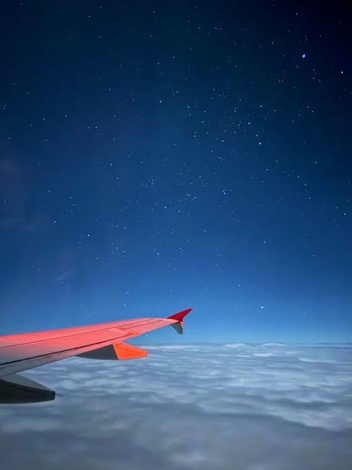 An airplane wing is seen in the sky with stars