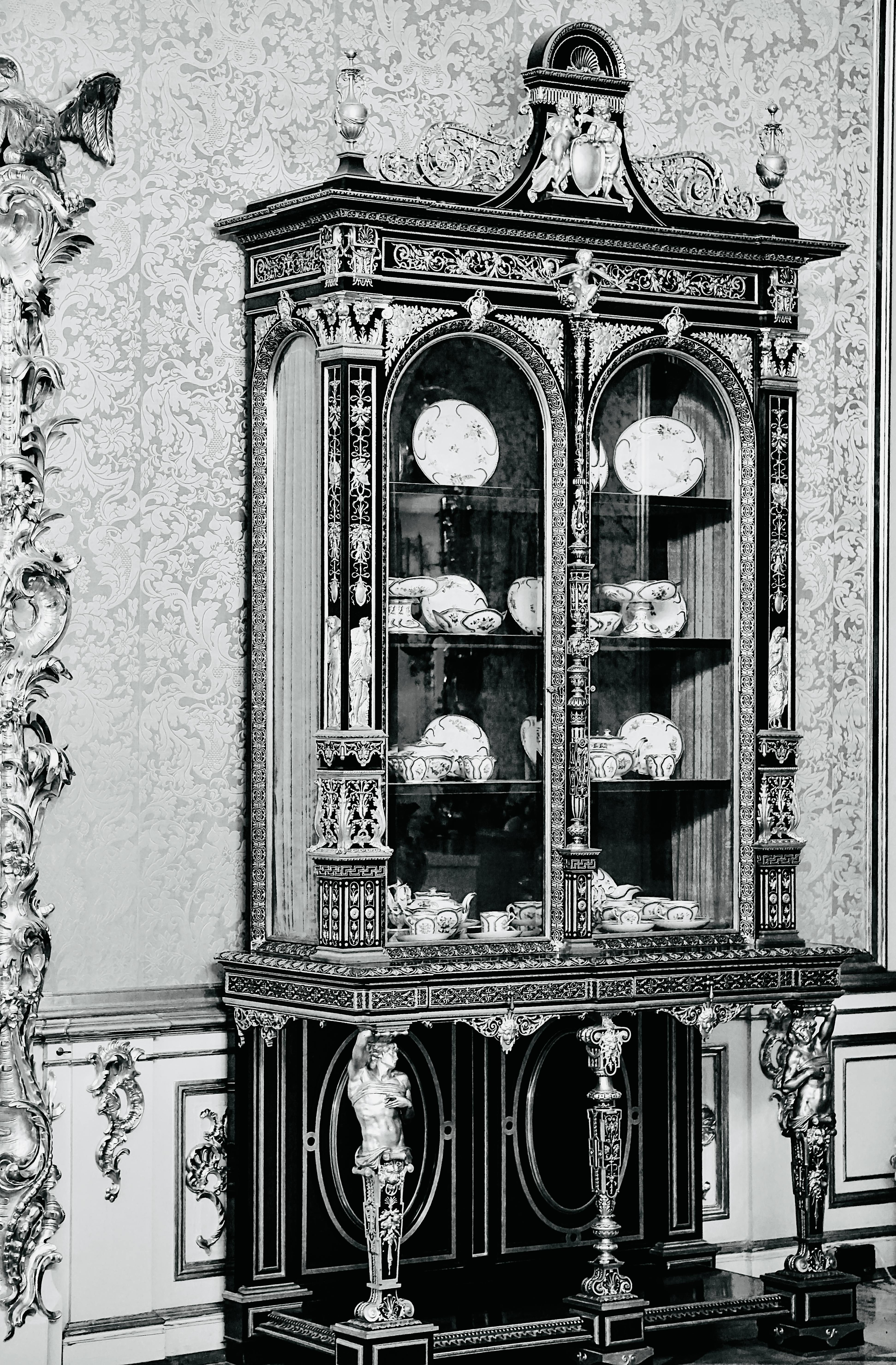 Free Ornate vintage cabinet displaying porcelain plates, exuding classic elegance. Stock Photo