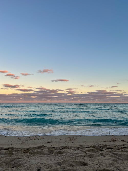 A beach with a blue sky and clouds