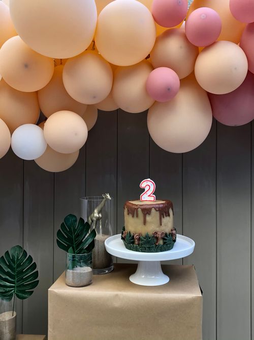 Free Lovely dinosaur-themed display for a 2nd birthday featuring balloons, cake, and party decor. Stock Photo