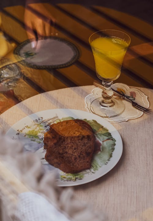 A plate of food with a glass of orange juice