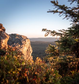 Breathtaking view of Szklarska Poręba landscape with rocky cliffs and forest under a clear sunset sky.