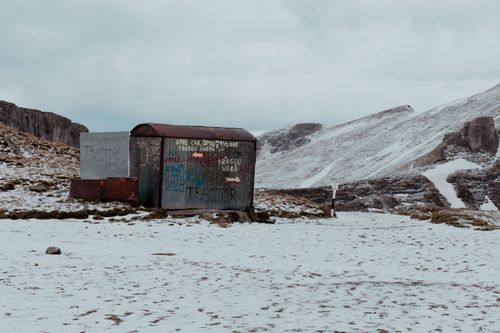 Free Abandoned shed in snowy Bușteni mountains, Romania, offers a serene winter landscape. Stock Photo