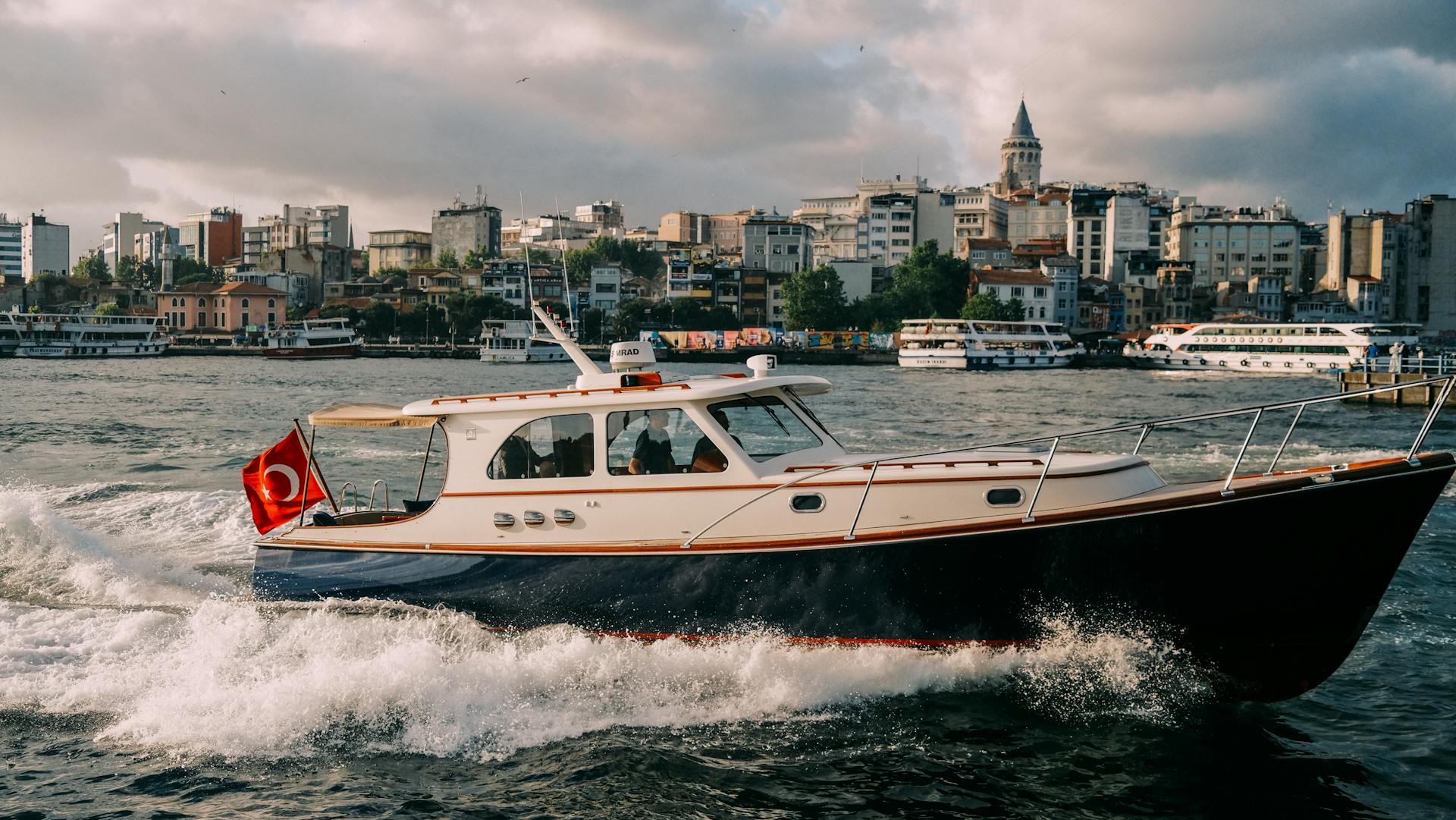 Elegant yacht sails near historic Istanbul skyline on the Bosphorus Strait.