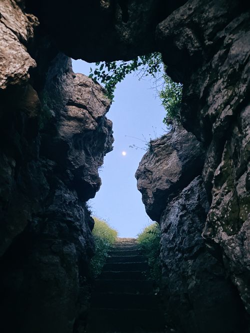 Free A rocky stairway emerges from a cavern leading to a clear sky, evoking a sense of exploration. Stock Photo