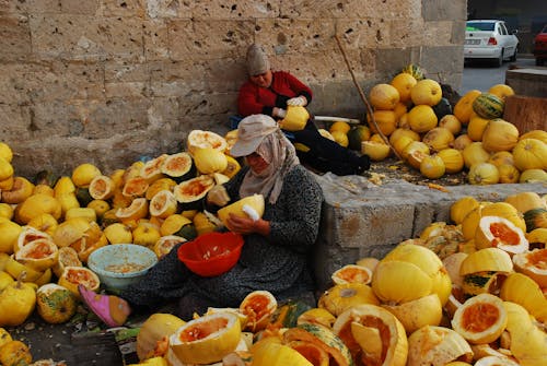 Women Sitting and Carving Fruits