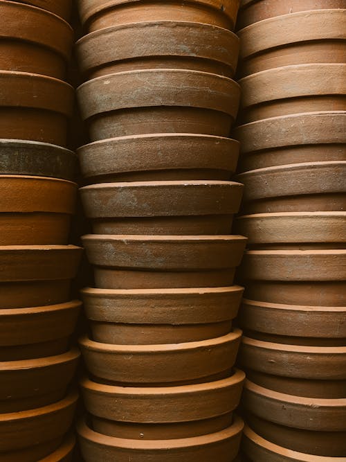 A stack of clay pots on a shelf