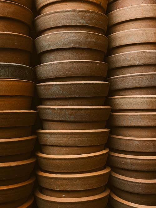 Free Close-up view of handmade terracotta pots stacked vertically, showcasing craftsmanship and earthy tones. Stock Photo