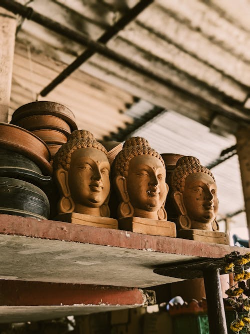 A shelf with several buddha heads on it