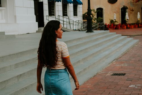 Photo of Woman Walking  Next to  White Building Staircases