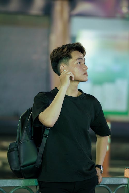 A man in a black shirt talking on his cell phone
