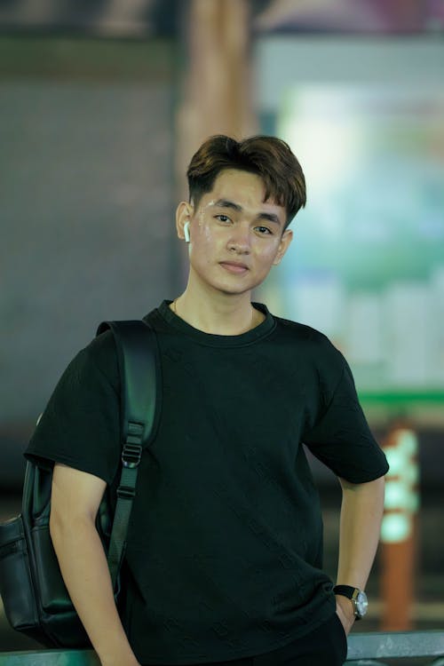 A young man in a black shirt and backpack