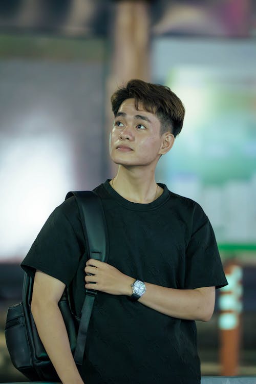 A young man in a black shirt and backpack