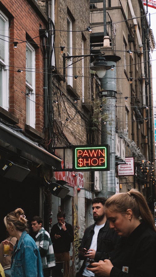 A group of people walking down a street with a sign that says, 'dawn shop'
