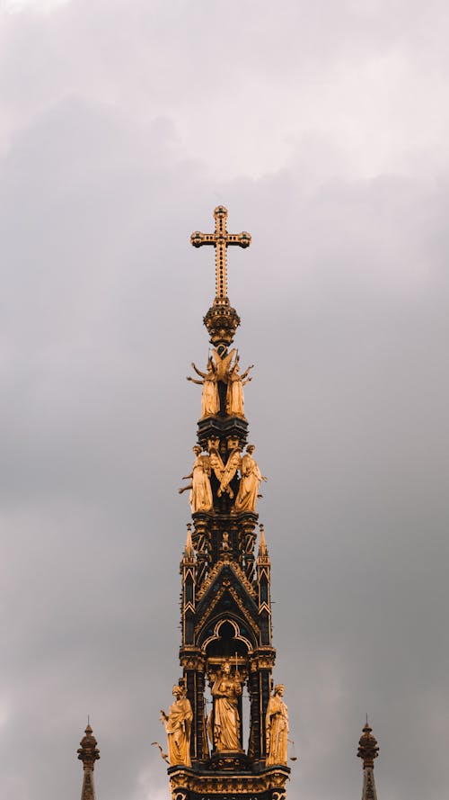 A gold cross on top of a tall building