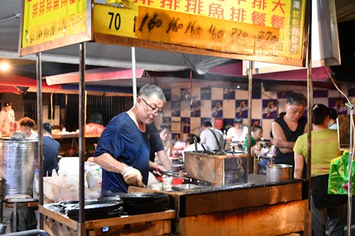 A man is cooking food in a food stand