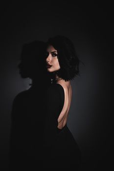 Sophisticated portrait of a brunette woman in a black dress, showcasing elegance and style.