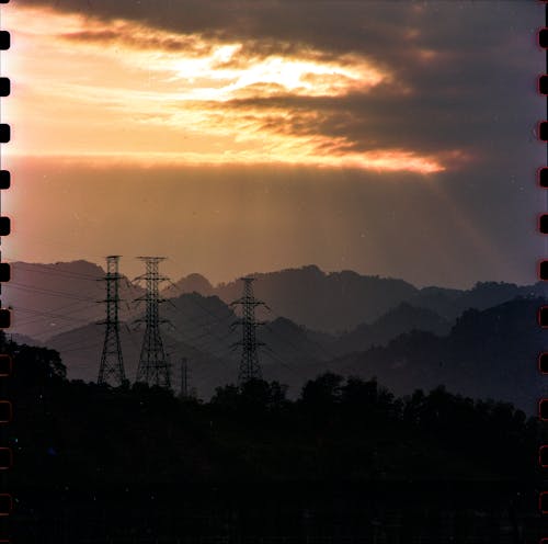 Sunset over the mountains with power lines and towers
