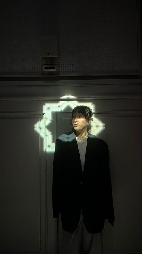 A man standing in front of a mirror with a light shining on him