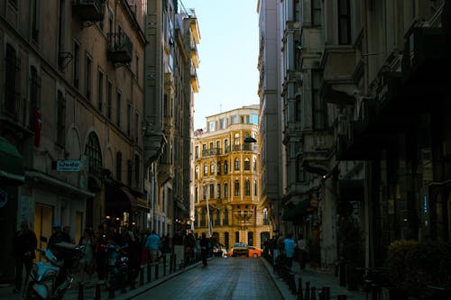 A city street with buildings and people walking down it