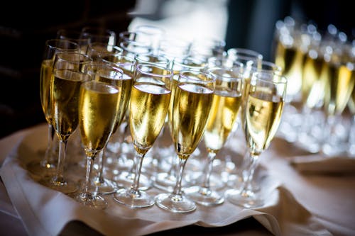 白い布で覆われたテーブルに金の液体と透明なワイングラス
