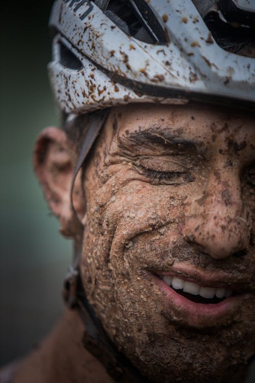 A man with mud on his face and helmet