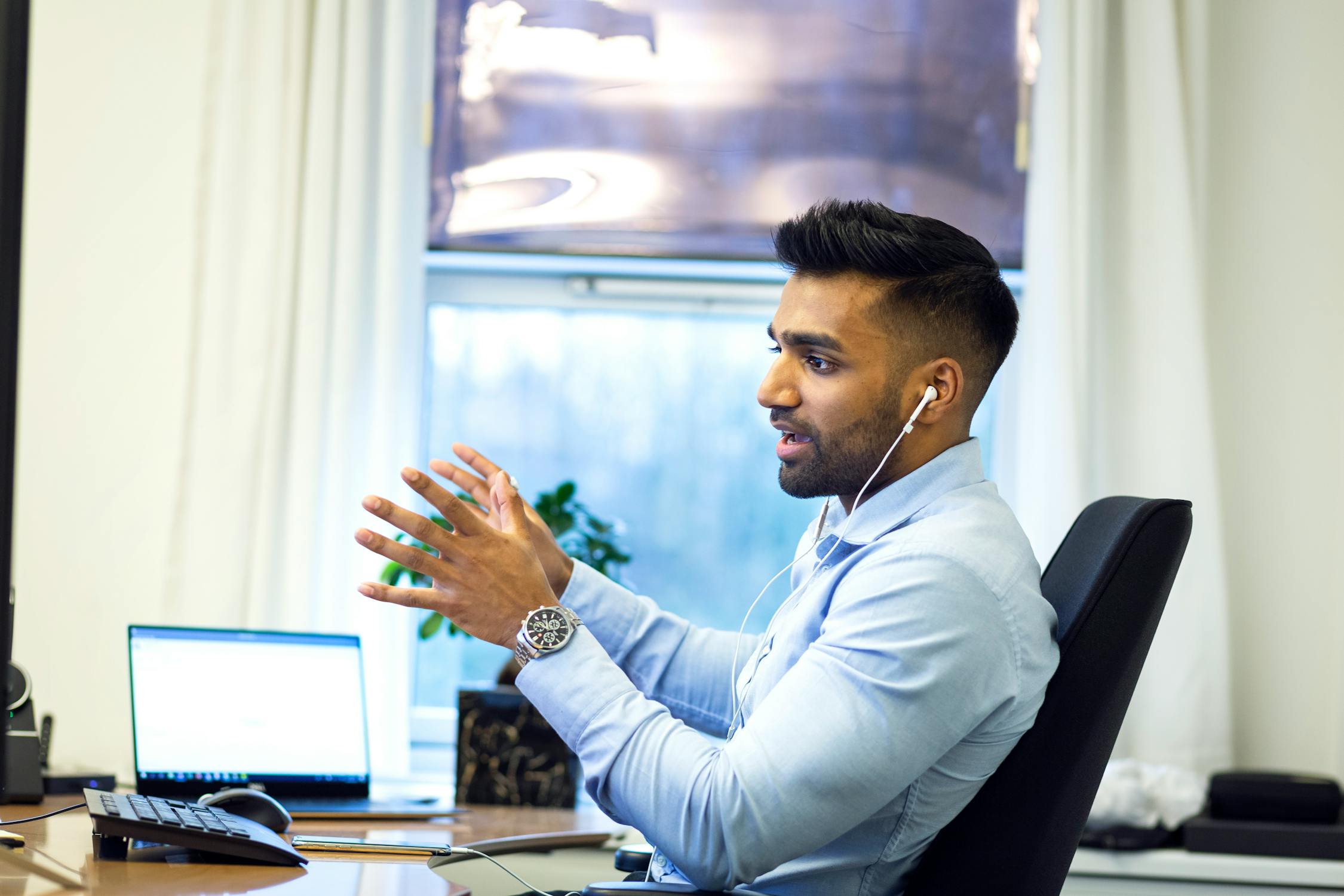 man on the phone through headphones sat on chair