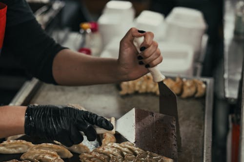 A person in gloves cutting up food on a tray
