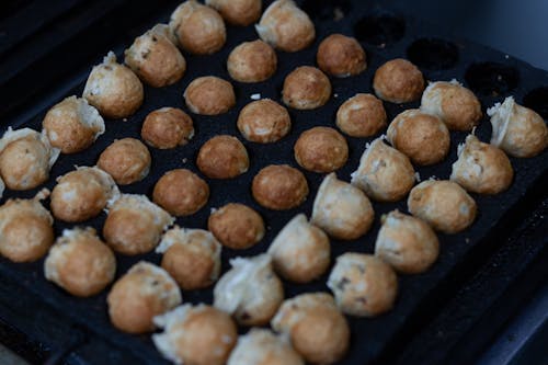 A tray of fried doughnuts on a grill