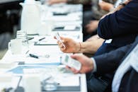 商务会议期间，手持设备的特写镜头突出了技术和笔记