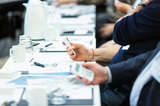 商务会议期间，手持设备的特写镜头突出了技术和笔记