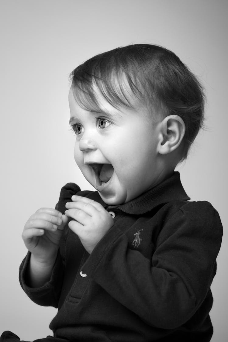 Grayscale Side View Portrait Photo Of Happy Baby Boy In Ralph Lauren Polo Shirt 